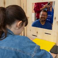 Student draws portrait of another attendee during Student Small Business Market.
